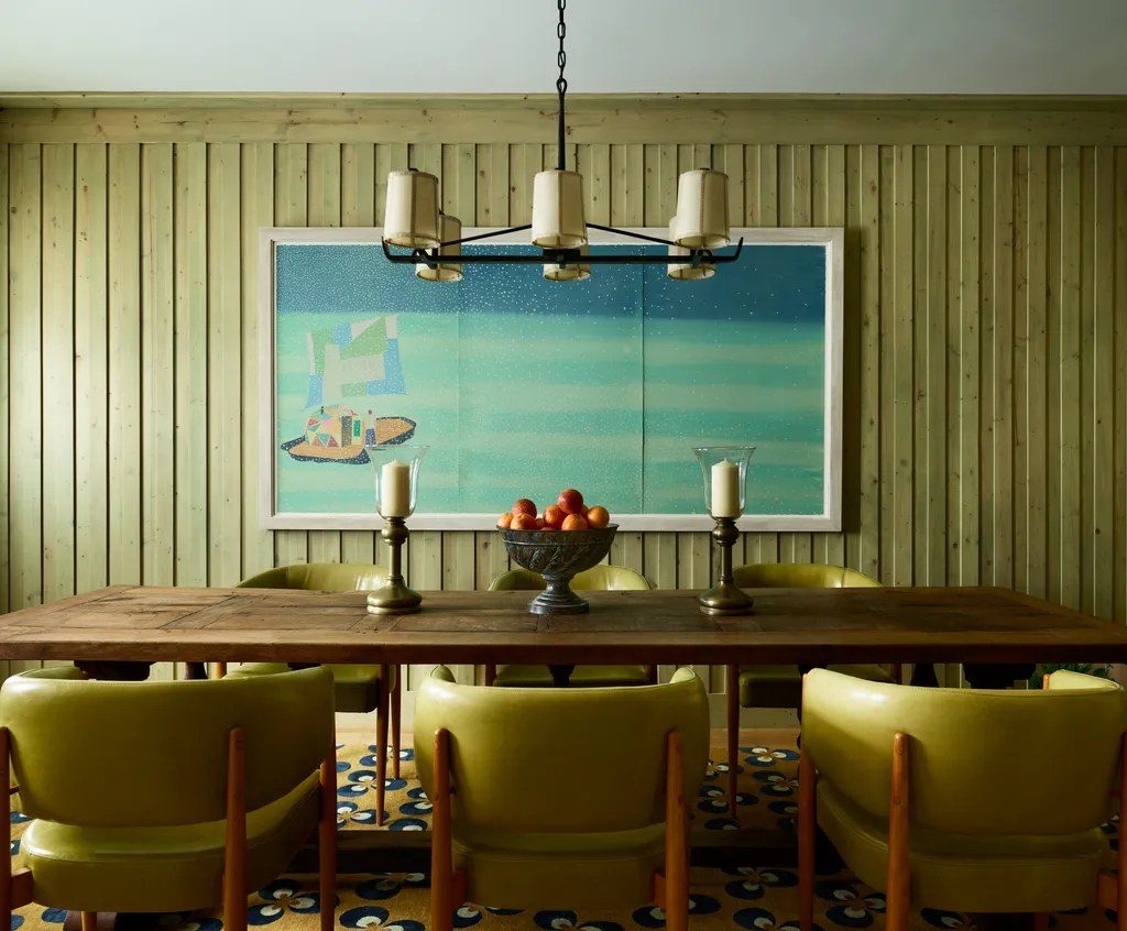 a green-paneled dining room with leather chairs