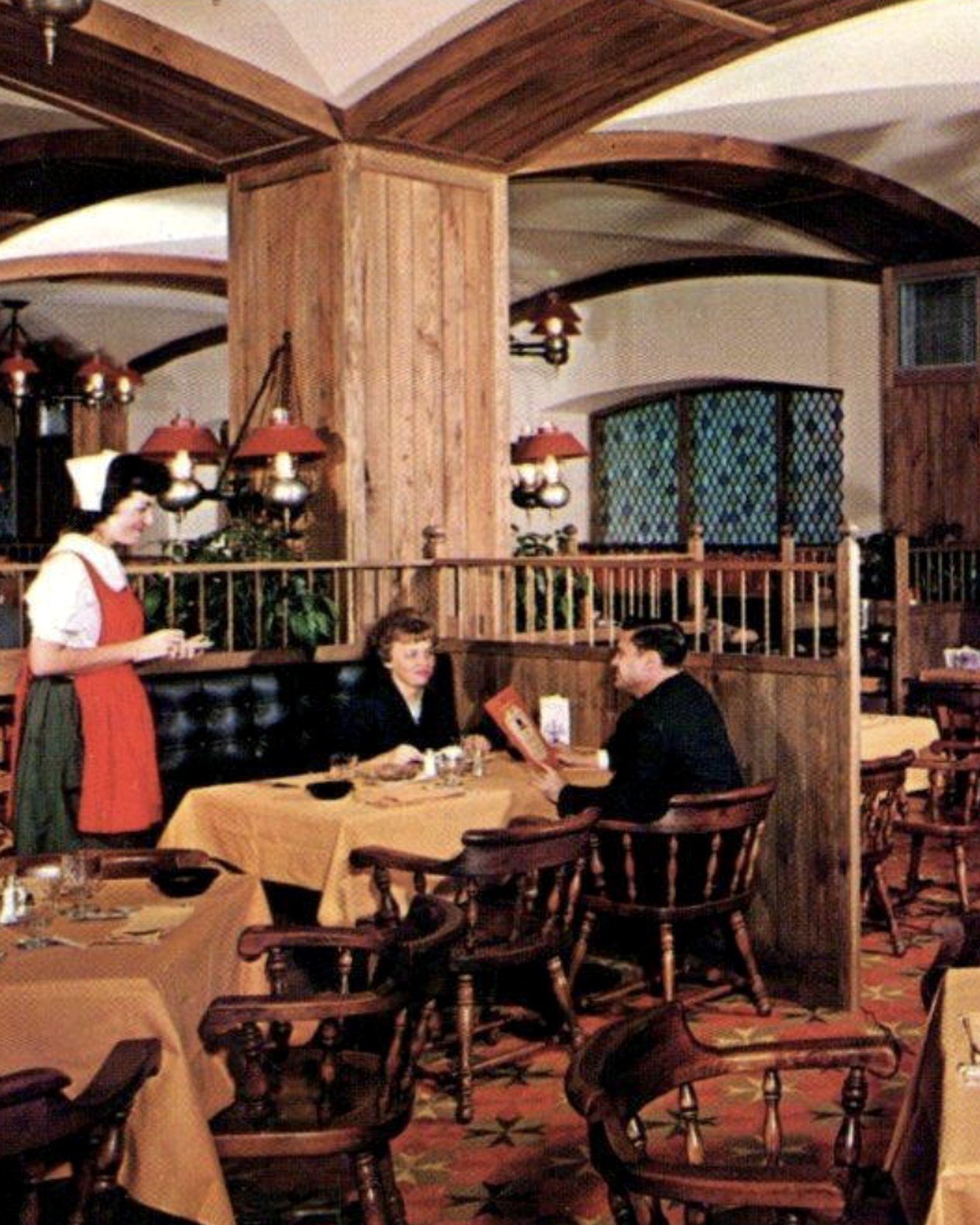 a 1960s restaurant dining room with waitresses taking orders