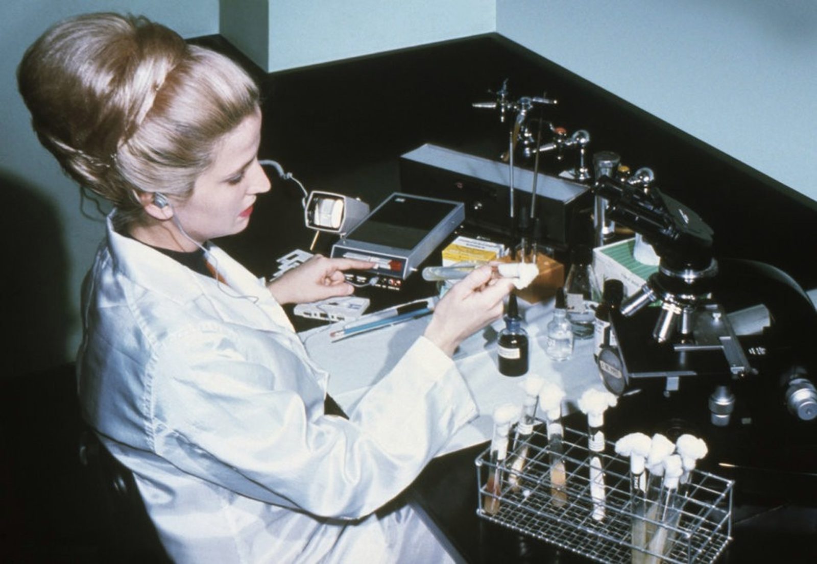 a scientist in a white lab coat preparing a sample at a laboratory bench