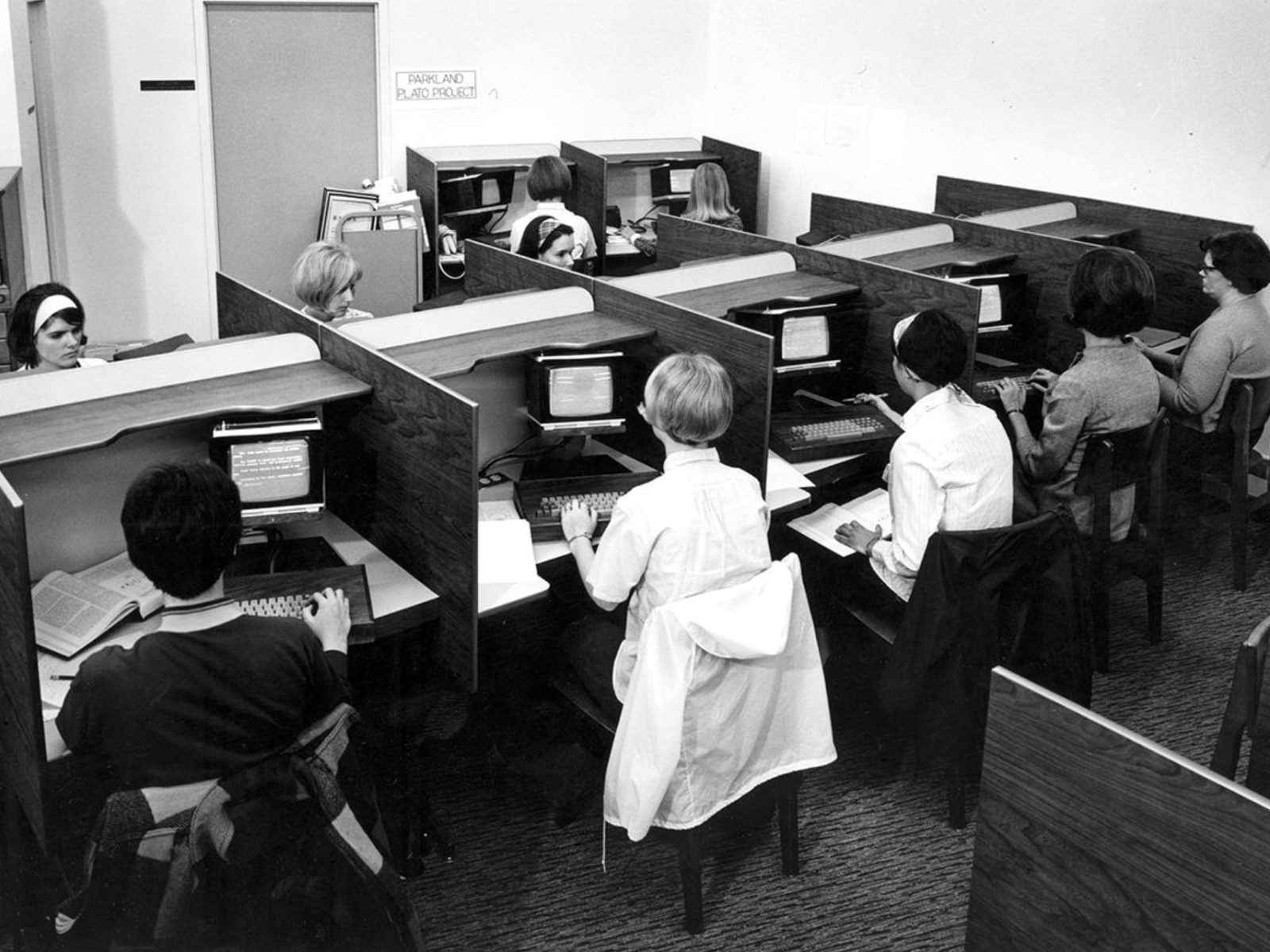 students working at plato computer terminals in wooden study carrels
