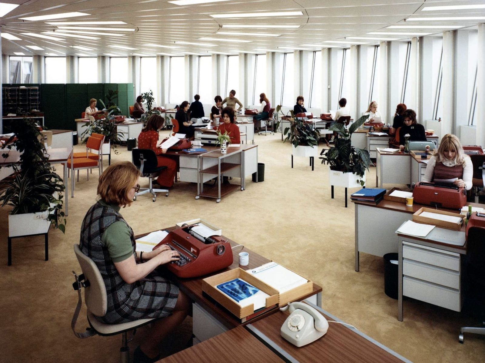 a 1970s open-plan office with typists at their desks
